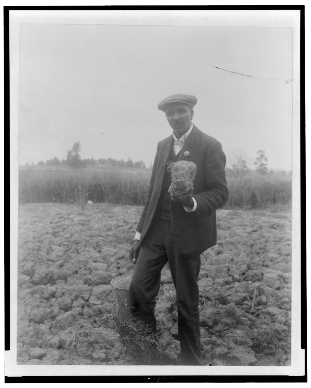 George Washington Carver_in field_holding soil_(c)_loc.gov